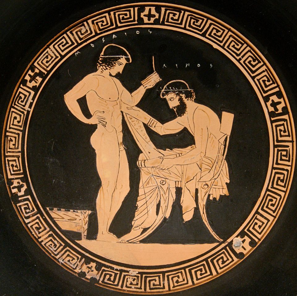 Linos is seated on the right. He holds a papyrus roll while the nude Mousaios stands in front of him holding writing tablets.